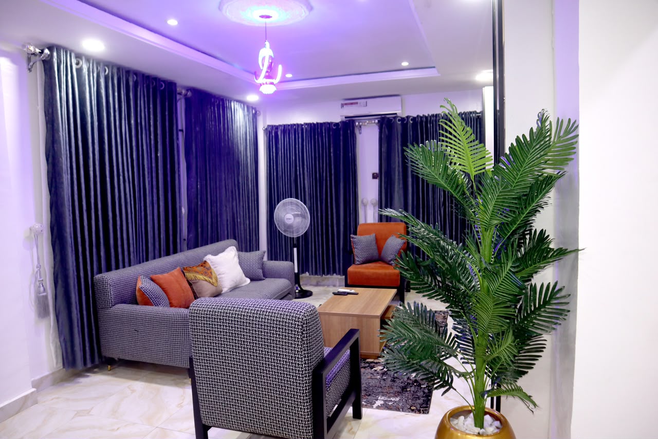 A wide, sweeping view of a magnificent modern living area with a charcoal modular sofa and a dark marble feature wall.